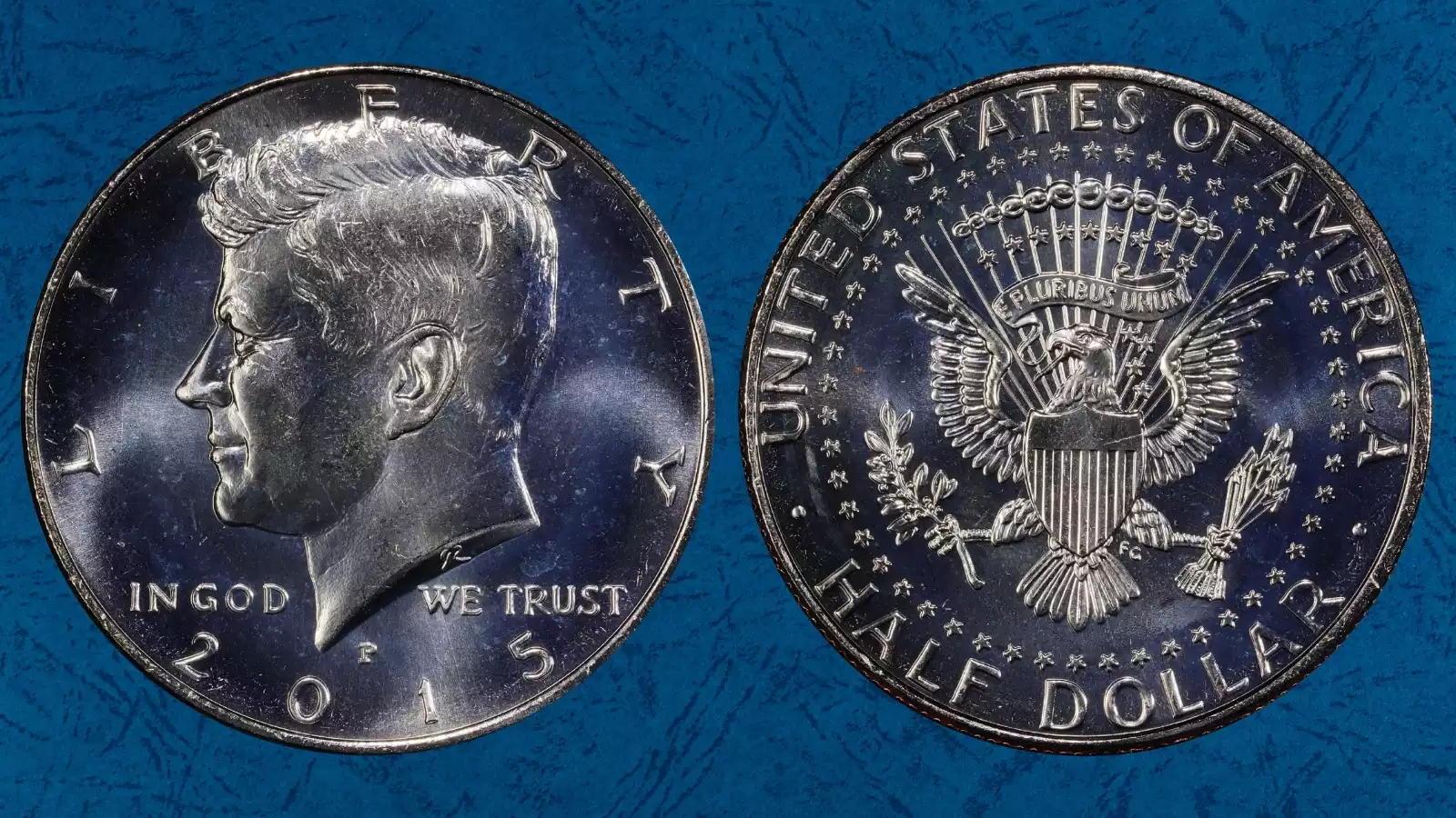 Grading strip showing four 2015 Kennedy half dollars from worn condition through gem uncirculated with grade labels
